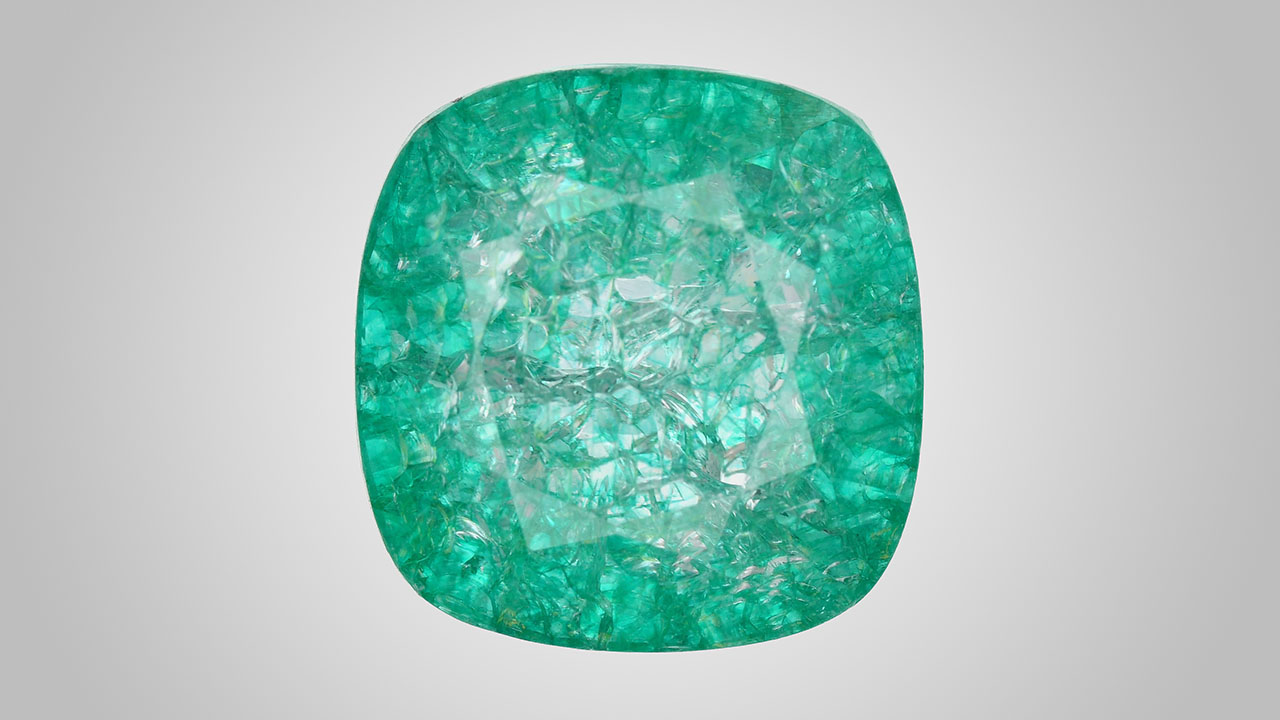 Figure 1. Face-up appearance of a quench-crackled and dyed laboratory-grown colorless sapphire, measuring 13.10 × 12.73 × 7.51 mm. Photo by Adriana Gudino. Figure 1. Face-up appearance of a quench-crackled and dyed laboratory-grown colorless sapphire, measuring 13.10 × 12.73 × 7.51 mm. Photo by Adriana Gudino.