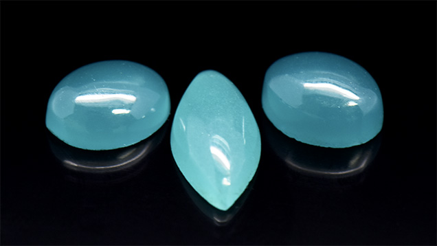 Three greenish blue glass cabochon samples. Three greenish blue glass cabochon samples.