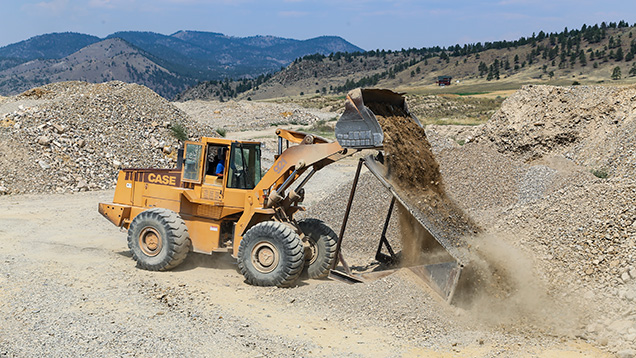Bulldozer dumping dirt on grizzly
