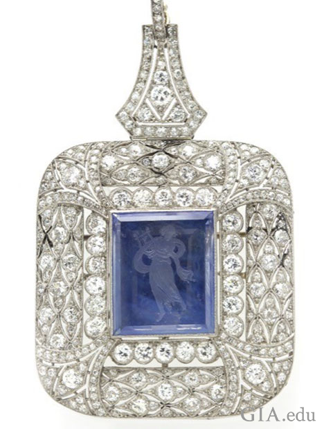 A square shaped pendant with a center reverse intaglio sapphire that is surrounded by diamonds.