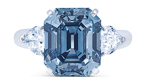 A rectangular cut Fancy Deep blue diamond is framed by two pear shaped diamonds.