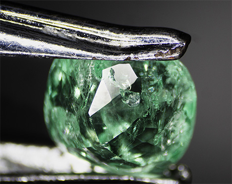 Emerald with a fiber trapped by liquid resin.