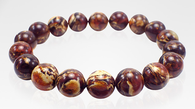 Dark brown “root amber” beads exhibit light yellow creamy swirls.