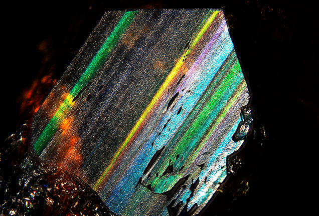 Figure 4. Sample G-1 displays strong iridescence with a full spectrum of colors. For certain bands, the color does not change as the viewing angle changes. This image is of a face parallel to (211). Photomicrograph by Jiuchang Yang; field of view 24.45 mm.