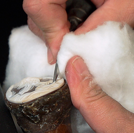 A carver holds the stick attached to a small cameo.