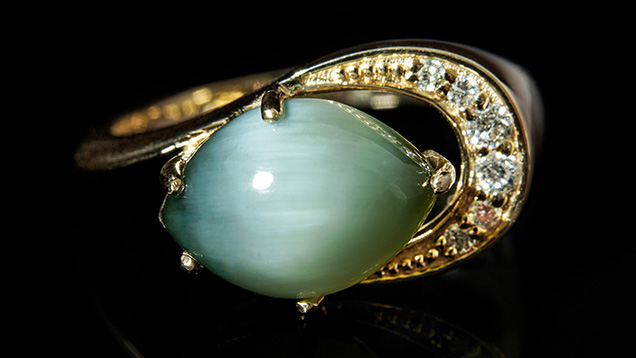 A 3.14 ct marquise cabochon nephrite set in a 14K yellow gold ring.