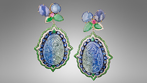 Figure 1. Surbhi’s “Orient” earrings with tanzanite carvings surrounded by blue sapphires, emeralds, white diamonds, and tsavorite garnets with an upper flower-shaped dangle composed of faceted tanzanites, emeralds, and pink sapphires, all set in 18K white gold. The total diamond weight for the pair is 1.60 carats, and the total colored stone weight is 62.23 carats, 48.32 carats of which are from the two tanzanite carvings. Photo by Robert Weldon; courtesy of YNY Jewels Inc. and Karats Inc.