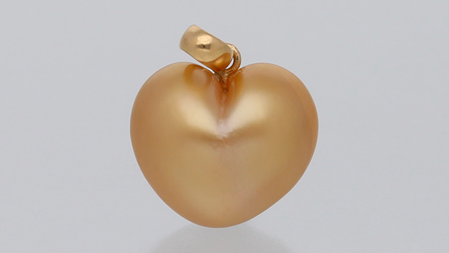 Figure 1. A heart-shaped golden South Sea pearl pendant measuring 17.78 × 11.65 × 9.07 mm and weighing 1.93 g (including the 18K yellow metal findings). Photo by Sood Oil (Judy) Chia.