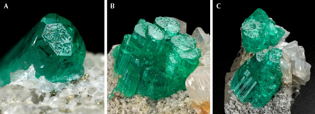 Figure 12. Emeralds with surface indentations on the basal face, developed as either a single crystal (A: sample 11, 4.1 mm in largest diameter) or as aggregates of parallel emerald crystals (B and C: samples 12 and 13 with crystal length up to 12.5 mm and 16.5 mm, respectively). Photos by G. Martayan.