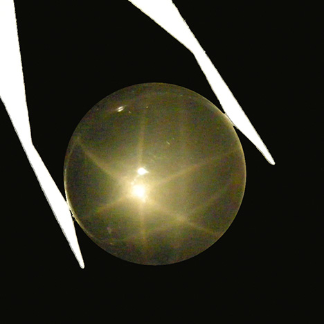 Very light rose quartz cabochon from Brazil showing double stars in reflected light