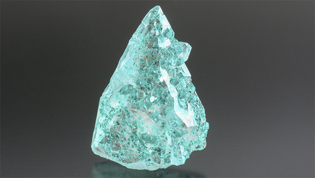 Colorless quartz crystal with blue-green dioptase inclusions.