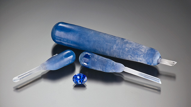 Figure 4. Flame-fusion synthetic sapphire boules and an oval-cut gem (2.45 ct). Photo by Robert Weldon. Cut stone gift of Aaland Gem Co. Inc., GIA Museum no. 24224.