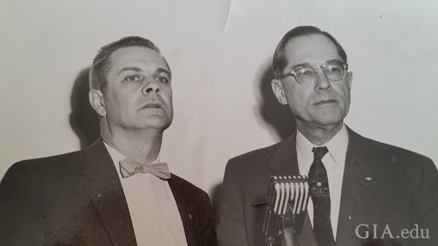 Two men in front of a microphone.