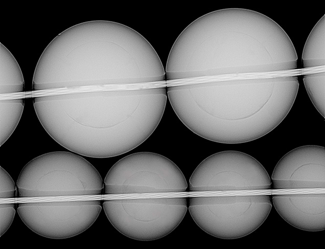 Figure 3. RTX image of freshwater BC pearls. The top strand, submitted for identification, has an average nacre thickness of 1 mm and an average bead diameter of 3.5 mm. The bottom strand, from the Hong Kong show, has an average nacre thickness of 0.8 mm and an average bead diameter of 2.7 mm. Image by Joyce Wing Yan Ho.