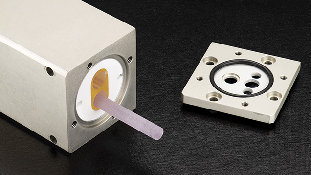 Figure 3. The laser head of one of the 213 nm laser ablation systems used at GIA. In this system, a Nd:YAG rod is housed in a chamber along with a xenon flash lamp that stimulates the production of 1064 nm fluorescence from the Nd:YAG. This fluorescence is frequency-quintupled to 213 nm light and focused into a laser. Photo by Emily Lane.