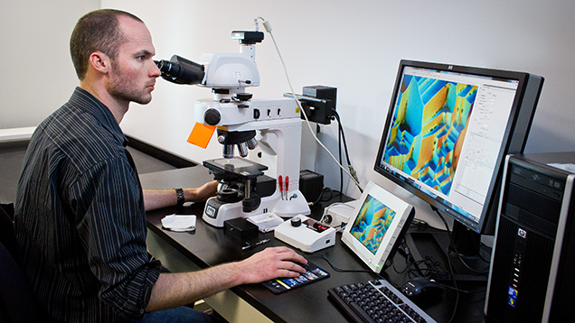 Figure 5. Nathan Renfro using the Nikon photomicroscope for observation and photography of inclusions and other micro-features at magnifications up to 1000×. Photo by Kevin Schumacher.